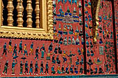 Wat Xieng Thong temple in Luang Prabang, Laos. the Ho Tai, the library. Colourful glass mosaics on a pink background with scenes of daily life. 